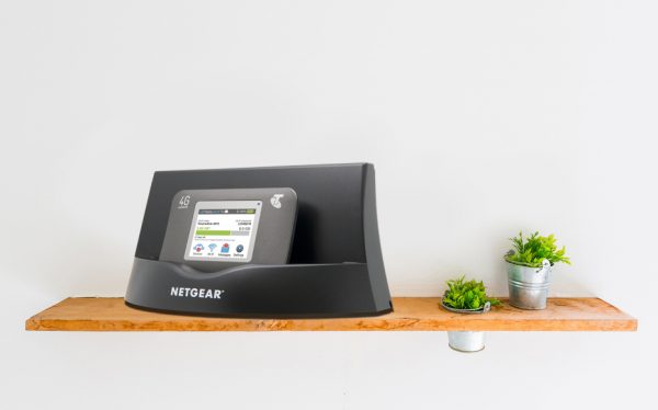 Портативный роутер Netgear Air Card 782S установлен в пластиковом боксе на деревянной полке