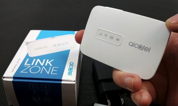 Рука держит мобильный роутер Alcatel Link Zone MW40